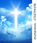 Cross in the cloudy sky with light rays