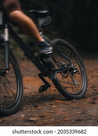 Cross Country Cycling In The Woods. Close Up Of Mountain Bike And Rider's Legs. Extreme Braking On The Forest Trails