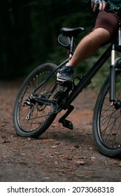 Cross Country Cycling In The Woods. Close Up Of Mountain Bike And Rider's Legs. Extreme Braking On The Forest Trails