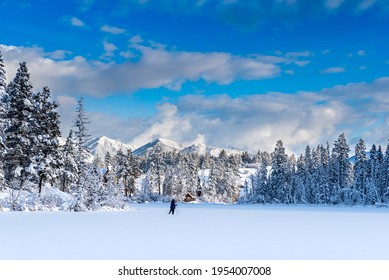 Cross country skiers on a newly frozen Lake Lillian near Invermere, BC, Canada