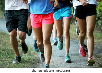 A Cross Country Team Runs A Workout In A Group In A Park Outside.