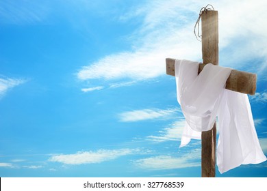 Cross with crown of thorns and cloth on sky background