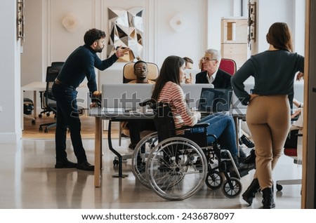 A cross generational group of professionals engage in a business meeting. The image includes a person using a wheelchair, depicting inclusivity and teamwork in a modern office setting.
