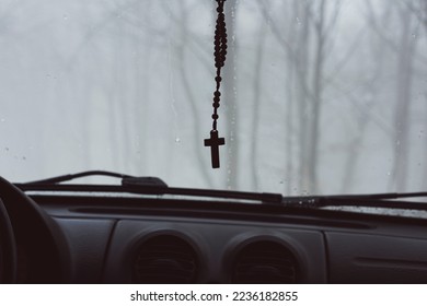 Cross hanging in a car in foggy weather