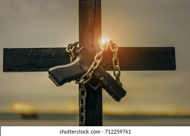 Cross holding gun with chain lock on prison the death concept.