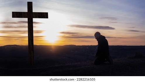 The cross of Jesus on the mountain. Prayer. Man on his knees praying. Crucifix. Forgiveness of sins and repentance. Easter. calm