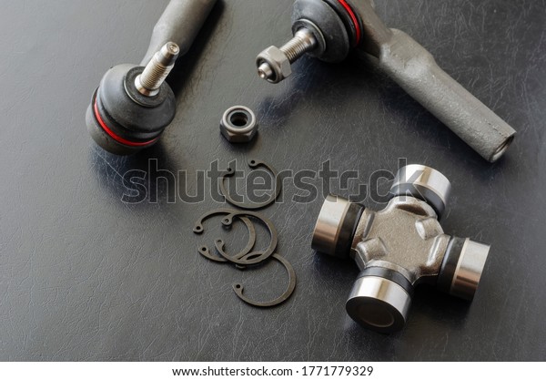 Cross joint of the propeller\
shaft and a set of tie rod ends. New auto parts for transmission.\
Trade Auto parts, car service. Automotive industry. Selective\
focus.