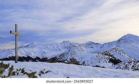 Cross on Mount Grześ in the Western Tatras. Snow-capped mountain peaks. - Powered by Shutterstock