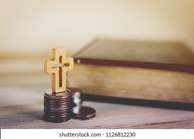 The cross on strac coin with the bible,Tithe concept - Shutterstock ID 1126812230
