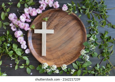 Cross on teak tray with frame of spring blossoms and branches with copy space