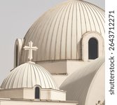 A cross perched atop a domed church building.