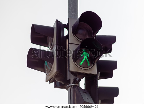 Cross road\
pavement traffic lamp. Green pedestrian icon means you can pass.\
Rules and warning signs regulating transportation. Obey the traffic\
light. Street light. Car and\
people.