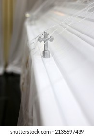 A Cross Screw On A White Casket