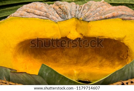 A Cross section of an Asian pumpkin and seeds removed. Golden texture of pumpkin meat with rough peal yellow-green skin