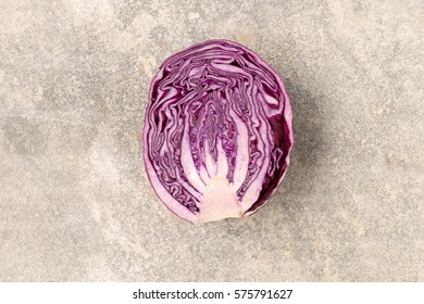 Cross section of a fresh red cabbage on concrete surface
