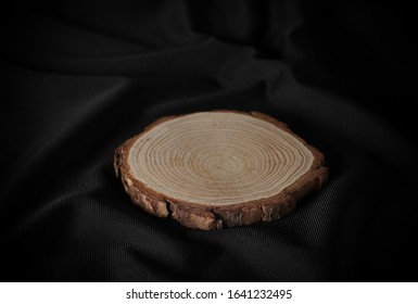 Cross section of tree trunk, stump on black fabric background