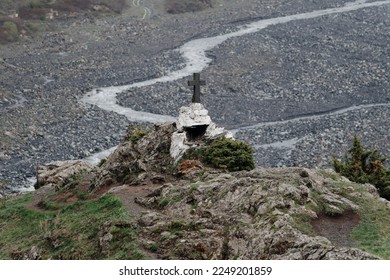 A cross sitting on top of a rocky hill - Powered by Shutterstock