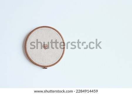cross stitch embroidery accessories. Linen cloth in hoop on white background with copy space. Indoor hobby concept.