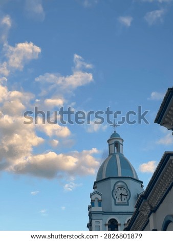 Belltower’s cross touching the sky.