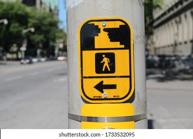 A Cross Walk Button Sign Showing The Direction Of Pedestrian Crossing In Ottawa, Ontario, Canada