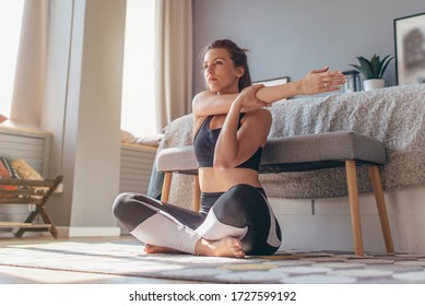 Cross-Body Shoulder Stretch. Woman at home does a warm up and stretch.