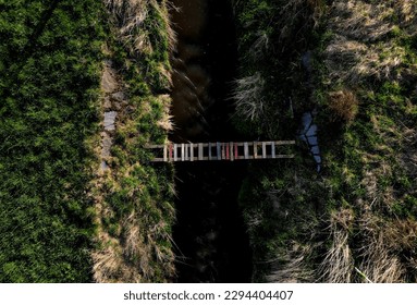 cross-country run through a flooded stream. footbridge with a thinly spaced plank floor. Big water in a narrow channel, video flight over the landscape. seed congestion - Powered by Shutterstock - Get 15% off with code: PIKWIZARD15