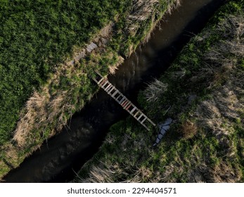 cross-country run through a flooded stream. footbridge with a thinly spaced plank floor. Big water in a narrow channel, video flight over the landscape. seed congestion - Powered by Shutterstock - Get 15% off with code: PIKWIZARD15