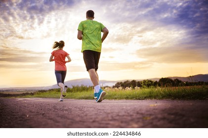 Cross-country Trail Running People At Sunset. Runner Couple Exercising Outside As Part Of Healthy Lifestyle.