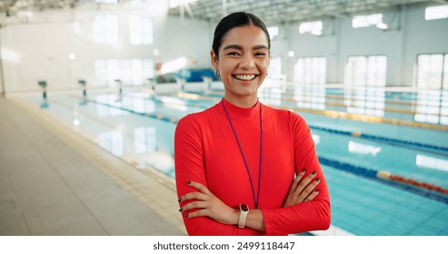 Crossed arms, woman and portrait of swimming coach at indoor pool for lesson, workout or training. Happy, confident and female lifeguard with pride for competition practice at aquatic center. - Powered by Shutterstock