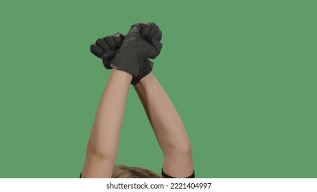 Crossed Hands In Black Gloves With Clenched Fists Raised For Protest On Green Screen. Symbol Of Solidarity, Support, Salute To Express Unity. Social Justice And Peaceful Protesting Racial Injustice.