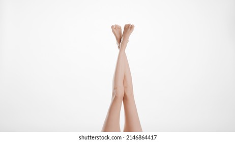 Crossed smooth female legs on light grey background | Leg care concept - Shutterstock ID 2146864417