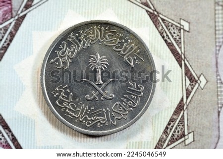 Crossed swords and palm tree at center of obverse side of old Saudi Arabia twenty five Halalah 25 halalas quarter Saudi Riyal coin 1400 AH, Translation of Arabic (King Khalid Bin AbdulAziz Al Saud)
