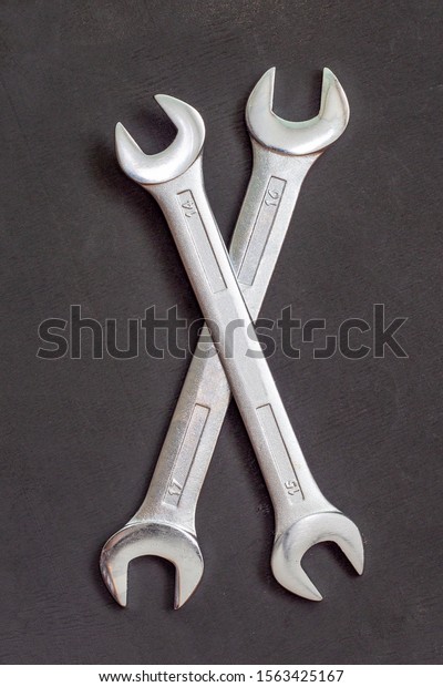 Crossed wrench\
symbol on black background. Two wrenches on top of each other.\
Service tool, auto repair\
concept.