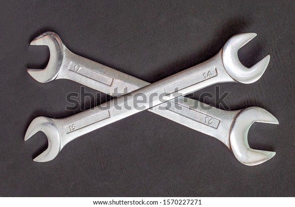 Crossed wrench\
symbol on black background. Two wrenches on top of each other.\
Service tool, repair\
concept.