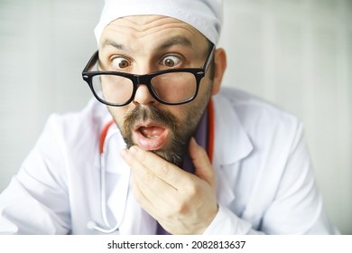A cross-eyed bearded man is looking into the frame. Eye disease. The concept of crazy medical specialist. Doctor neighbor.