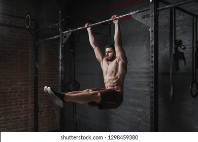 Crossfit athlete doing abs exercise on horizontal bar at the gym. Handsome man doing functional training workout. Practicing calisthenics.
  - Powered by Shutterstock