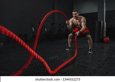 Crossfit Battle Ropes Exercise During Atlete Training At The Workout Gym. Man Training With Rope. The Sport Motivation Concept. Copy Space.