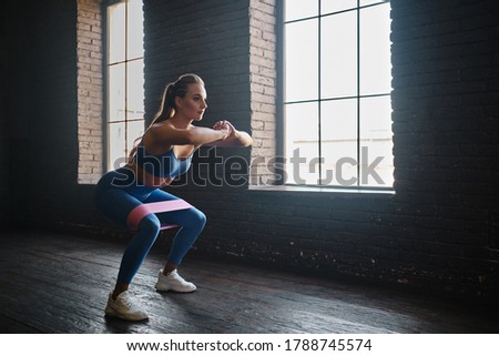 Crossfit healthy concept. Woman wearing sport clothing using resistance band