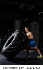 Crossfit Training - Man Flipping Tire In Gym