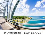 Crossing the Blue Water Bridge west from Canada to the United States Border in Port Huron, Michigan. A view from car shows steel bridge beams in foreground, Lake Huron and American soil.