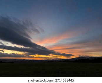 Crossing cloud layers illuminated after sunset against blue sky
