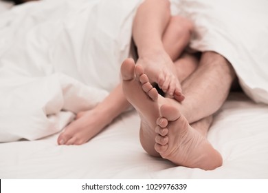 Crossing Feet Of Couple In Bed. Sex Concept.