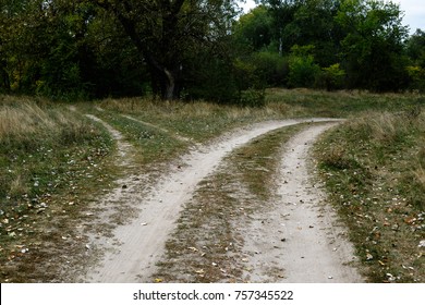 Crossroads, two different directions in the field at summertime. Concept of choose the correct way