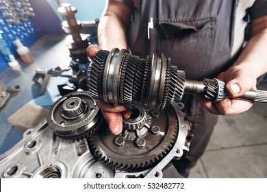 Cross-section of a car gearbox. mechanics work in the garage. hand mechanic in working clothes