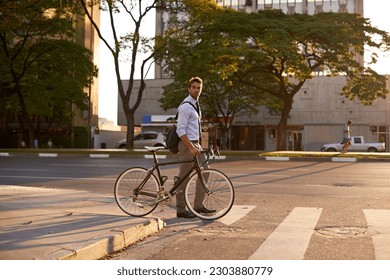 Crosswalk, bike and business man in city for morning, sustainable travel and carbon footprint. Cycling, transportation and urban with employee walking on commute for journey, transit and professional