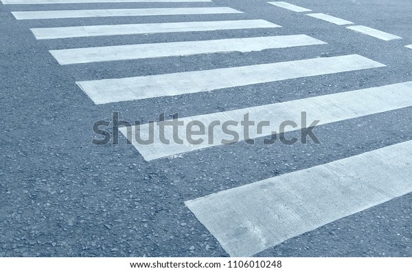 Crosswalk on the asphalt road at the\
junction of city for safety. Black and white\
crosswalk.