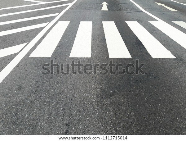 Crosswalk on the asphalt road at the\
junction of city for safety. Black and white\
crosswalk.\
