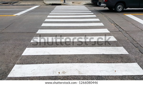 crosswalk on the road for safety when\
the car has passed the white crosswalk sign in the\
morning