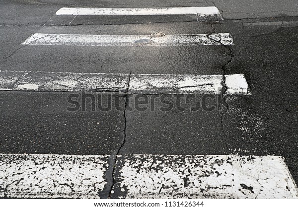 Crosswalk,
White Lines in Street, Concrete and Pavement
