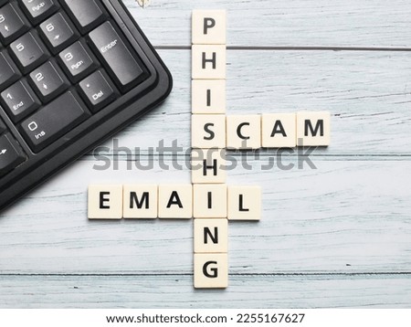 Crossword phishing scam email made from square letter tiles with computer keyboard.